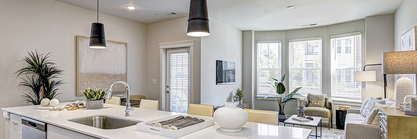  Kitchen island and living room inside an upscale apartment